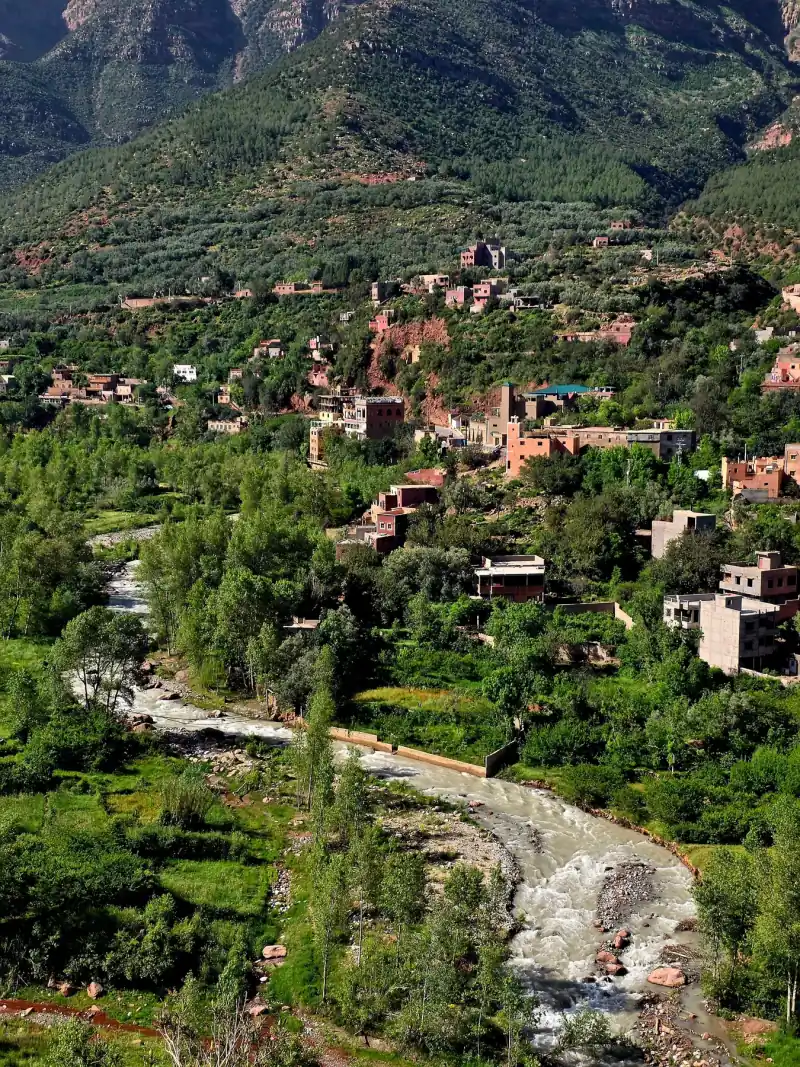 Green river valley in the Atlas Mountains with a village and terraced fields on the slopes