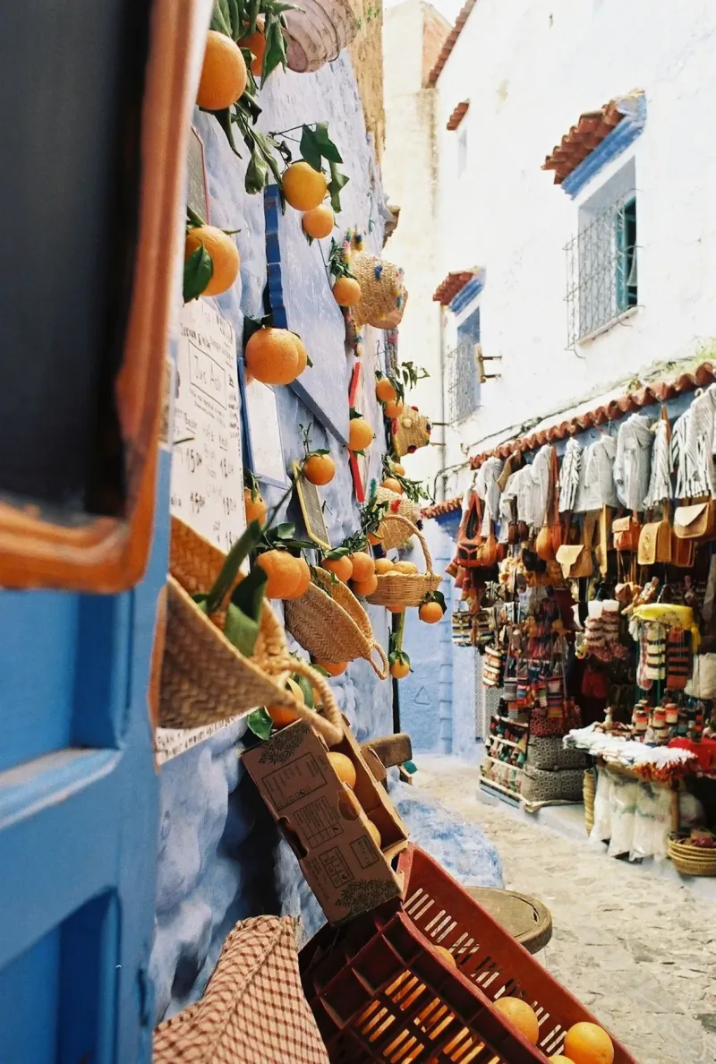 Handicrafts, baskets and woven goods displayed on a blue wall in the Chefchaouen medina