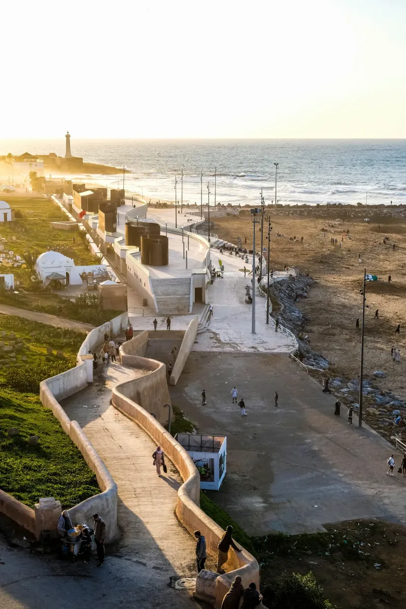 Whitewashed walls and a lighthouse on Rabat's Atlantic shoreline in warm evening light